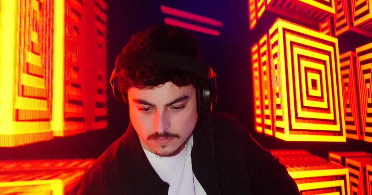 DJ OTEO performing behind the decks under red LED wall lighting